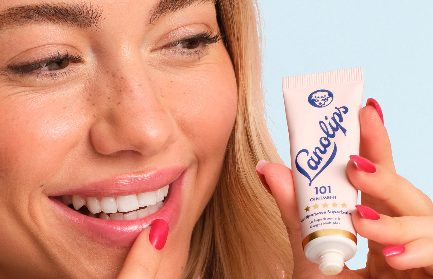 Model holding a lanolips 101 ointment multipurpose superbalm tube in her hand.