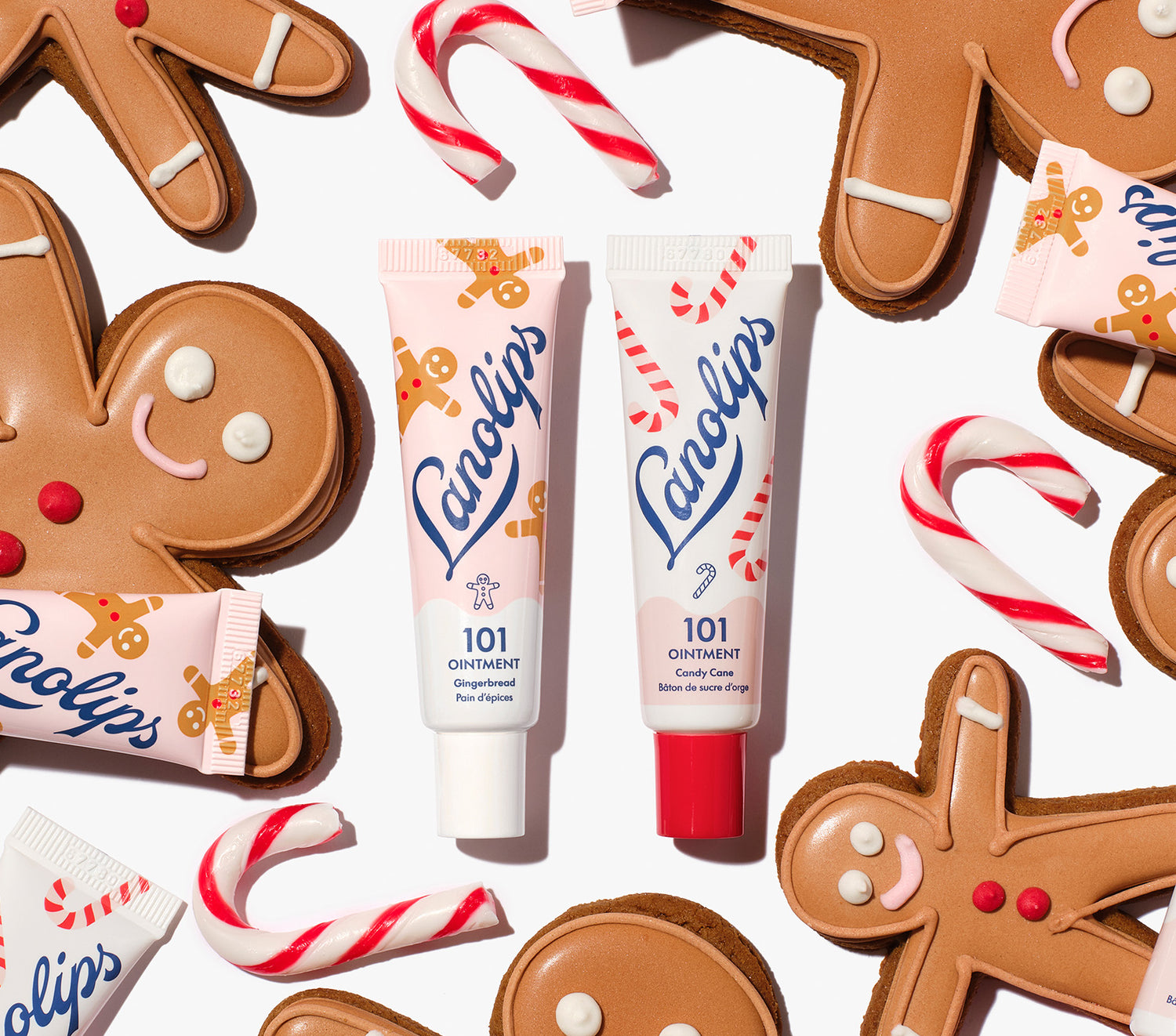 Lanolips 101 Ointment Multi-Balm Gingerbread & Candy Cane, styled with gingerbread cookies and candy canes, part of the limited-edition Holiday Gingerbread House Lip Duo. Enriched with lanolin, vitamin E and natural flavours for soft, hydrated lips.