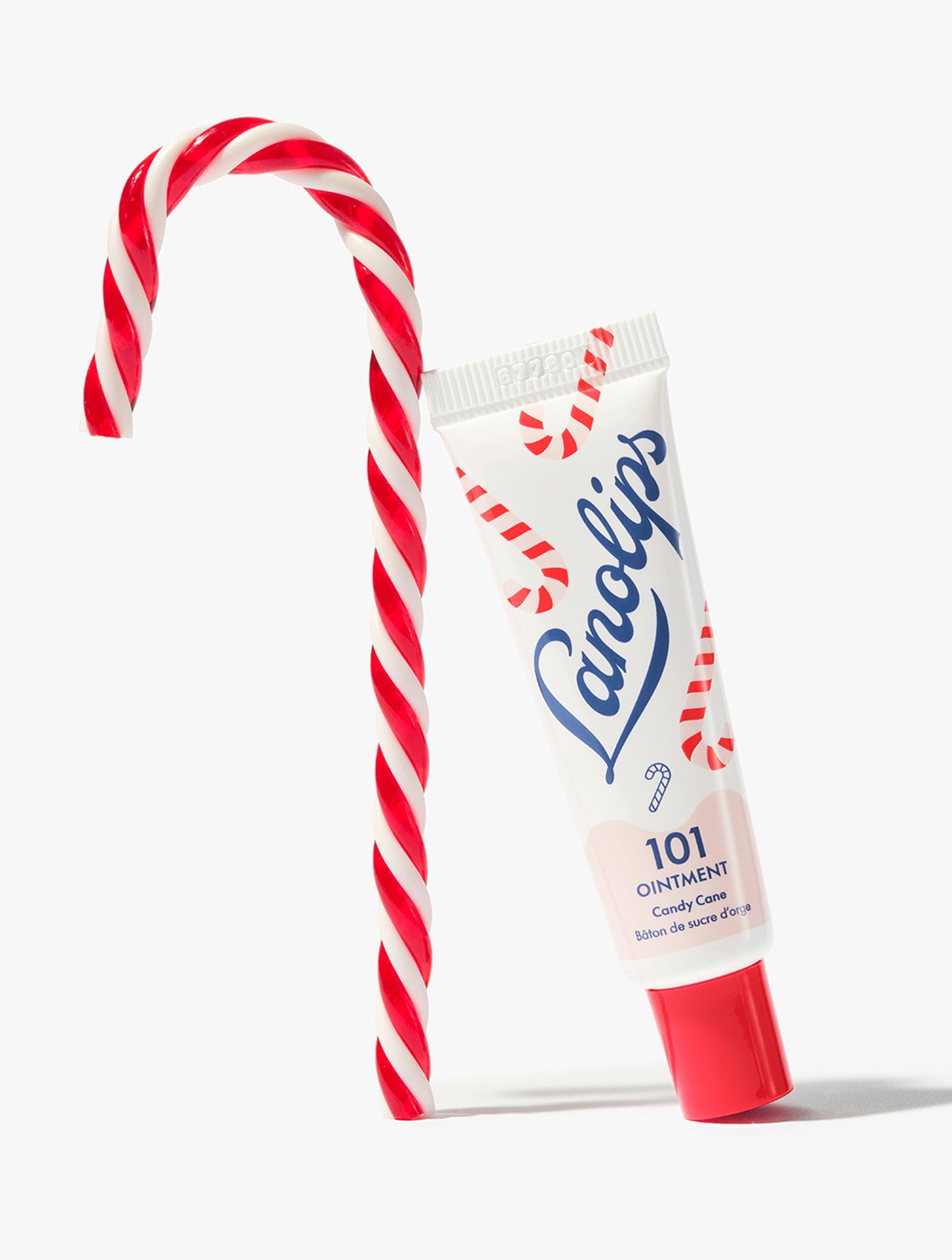 Lanolips 101 Ointment Multi-Balm Candy Cane lip balm leaning candy cane lolly, against a white background.